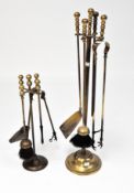 Two early 20th Century brass fireside companion sets, each with brushes, tongs and shovels,