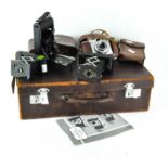 A vintage leather briefcase containing four cameras,
