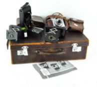 A vintage leather briefcase containing four cameras,