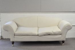 A contemporary two seater sofa, upholstered in patterned fabric, on wheeled wooden supports,
