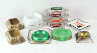 A collection of vintage ash trays, including three glass and two plaster 'Woodbines',