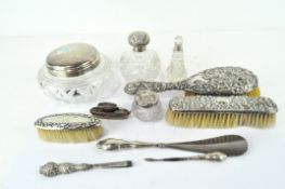 A selection of silver dressing table wares, including highly embossed brushes, a lidded pot,