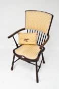 A 19th Century upholstered Windsor chair, with tapered supports and a spindle back,