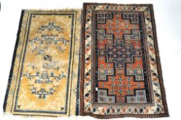 Two rugs, one of Chinese design with blue and white scroll pattern on a yellow ground,150cm x 95cm,