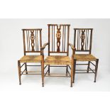 Three early 20th century rush-seated,wheel back chairs on lightly tapered legs and bun feet,