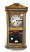 A vintage Vienna-style wall clock with face and pendulum visible behind glass,