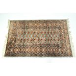 A contemporary green and russet Persian style rug with a geometric pattern,