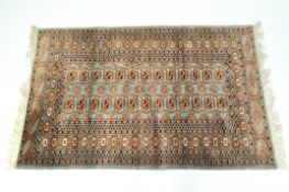 A contemporary green and russet Persian style rug with a geometric pattern,