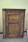 A 19th century oak corner cupboard, opening to reveal three shelves,