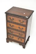 A late 19th-early 20th century side cabinet, mahogany veneer, four drawers with metal handles,