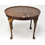 A 20th century small mahogany veneered table of circular form, on cabriole legs,