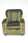 A vintage green upholstered armchair, with carved detailing to the front, raised upon castors,