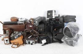 A collection of vintage cameras and camera bags, including a Bell & Howell film camera,