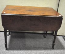 A Georgian mahogany Pembroke table with reeded edge, rounded corners and turned legs on casters,