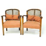 A pair of early 20th century mahogany bergere armchairs, each with crescent backs, squared legs,