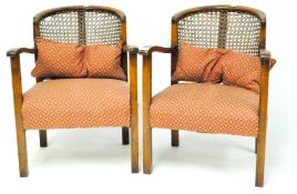 A pair of early 20th century mahogany bergere armchairs, each with crescent backs, squared legs,