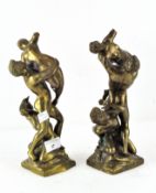 A pair of cast brass sculptures, featuring figures in dramatic poses,