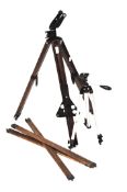 A collection of tripods, including vintage early 20th century wooden examples and a metal example.