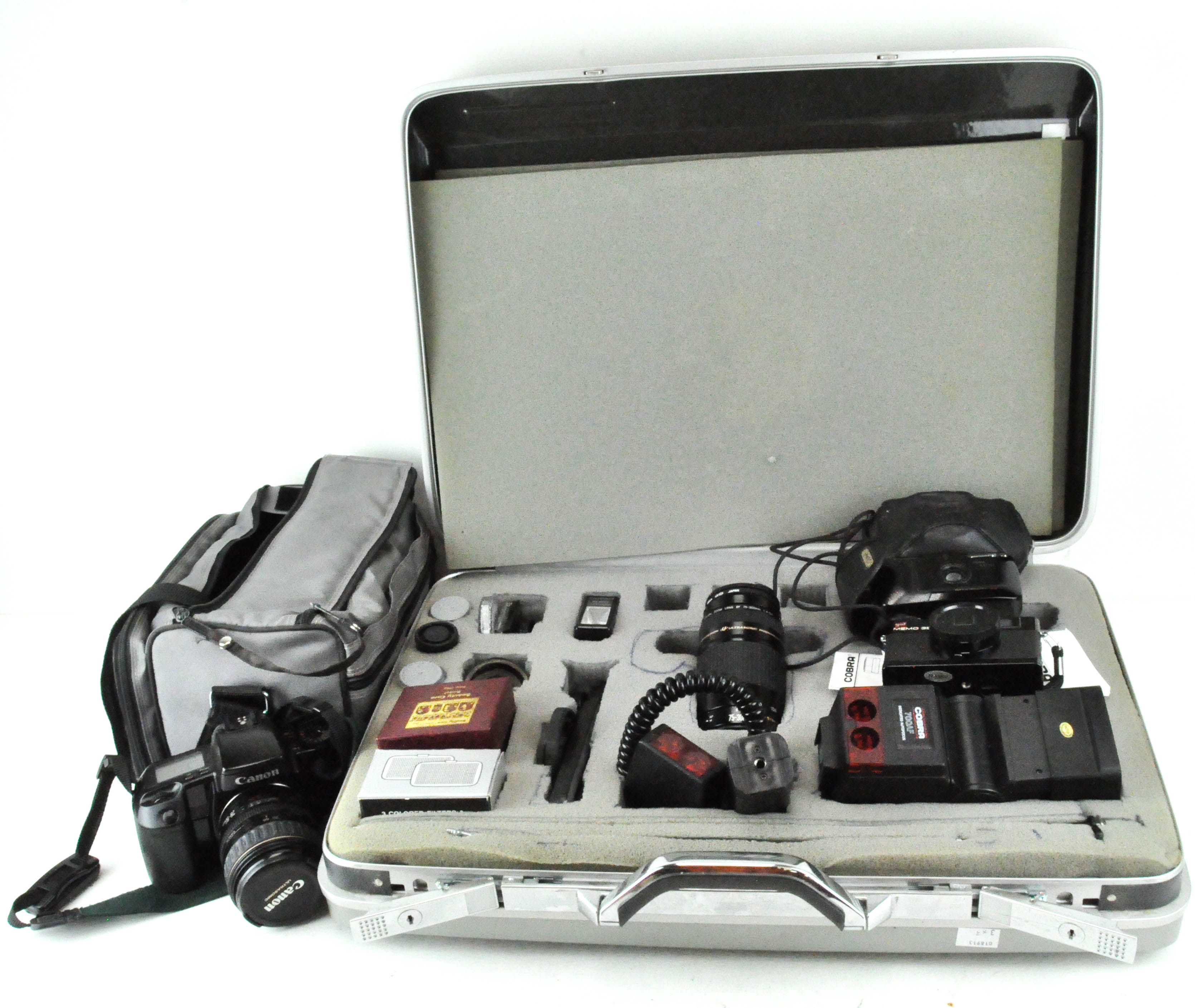 A collection of cameras and lenses, including a Cobra 700AF, Canon Ultrasonic EOS 100 camera