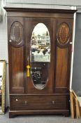 A large early 20th century mahogany wardrobe with inlaid banding and oval ribbon pattern flanking