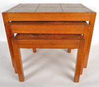 A nest of three tables, the top of each one decorated with brown tiles, wooden frame,
