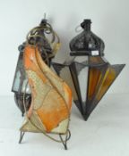 A group of three middle eastern style lamp shades and a floor lamp,