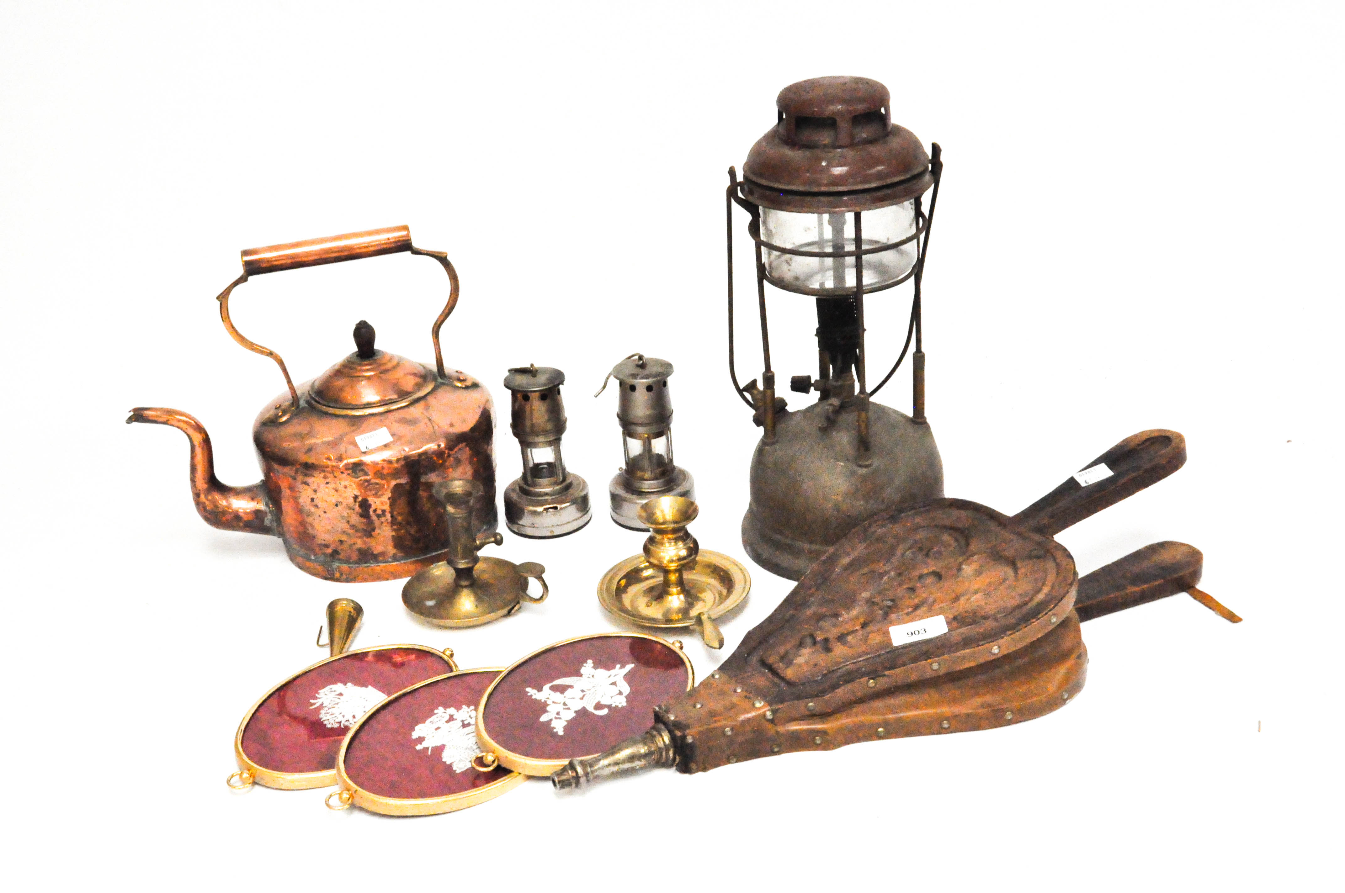 A group of vintage metalware including a copper kettle and bellows, lamps,