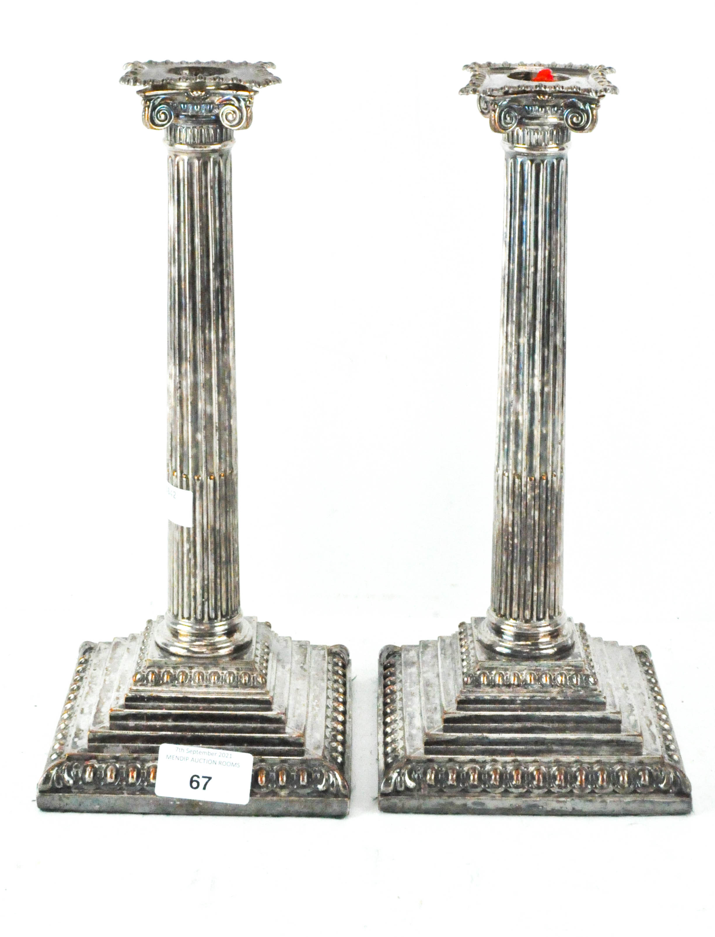 A pair of silver-plated neoclassical candlesticks, the columns,