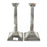 A pair of silver-plated neoclassical candlesticks, the columns,