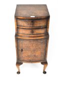 A 1920's walnut bow fronted bedside cabinet, two drawers to the top with a door beneath,