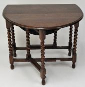 An oak drop leaf table on barley twist legs, with plain stretchers,