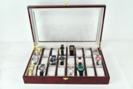 A modern watch collection box with clear top, containing a selection of wristwatches,