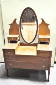 A mid-century dressing table with oval swing mirror above six drawers, with cross grain detailing,