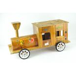 A vintage homemade wooden 'sit-on' train, with hinged doors and decorated with flowers and animals,