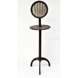 A late 19th century mahogany shaving stand, with adjustable mirror to top above a circular shelf,