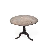 An early 19th century oak tilt top table, of circular form, raised upon turned tri-pod support,