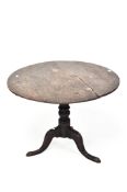 An early 19th century oak tilt top table, of circular form, raised upon turned tri-pod support,