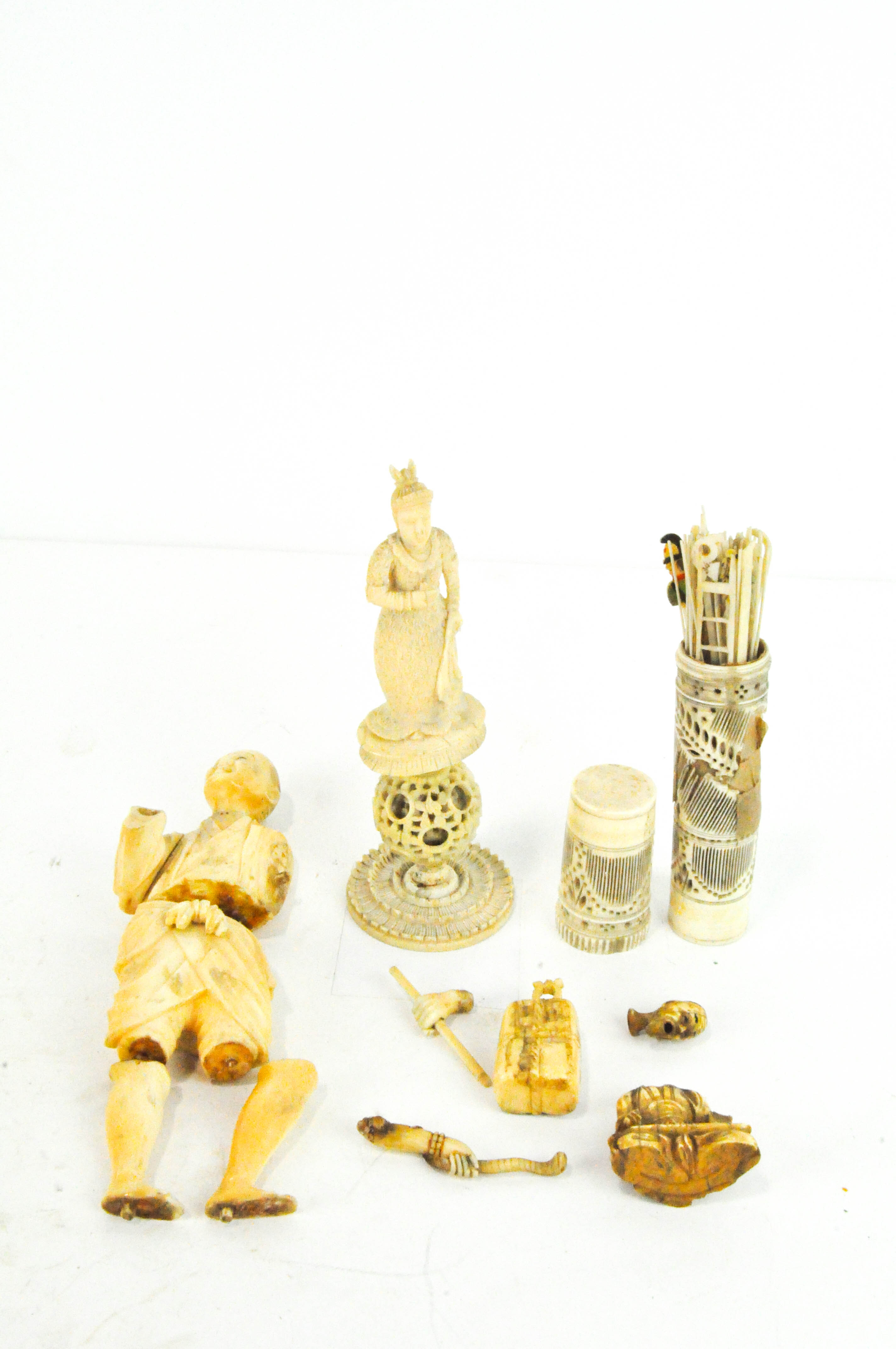 A selection of carved ivory, including standing and seated figures, a puzzle ball and more,