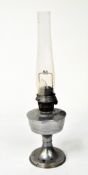 A 20th Century oil lamp, with glass funnel, on circular base,