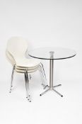 A set of four modern white chairs on chrome supports, together with a glass topped tilting table,