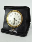 An early 20th century leather cased travelling clock, silver dial with Arabic numerals,