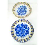 A pair of 19th Century Continental tin glazed pottery chargers, decorated with flowers and foliage,