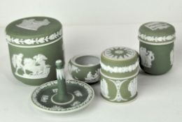 A collection of six Wedgwood dipped green jasperware ornamental jars and covers and a ring tree,