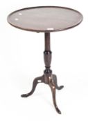 A Georgian mahogany tilt top tripod table with raised lip on turned support,