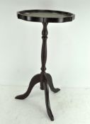 A small modern circular occasional table with scalloped edge and green leather inset,