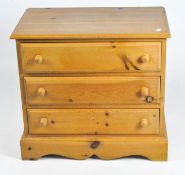 A small pine chest of drawers, with three long drawers, on bracket feet