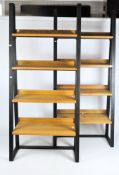 Two modern oak and black metal A-frame shelves, each with four shelves,