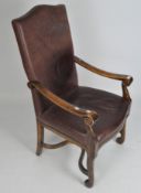 A reproduction Continental style scroll arm oak chair, upholstered in brown leather,