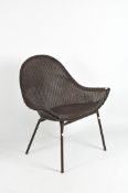 A Lloyd Loom style dark brown wing chair on a thin metal frame,