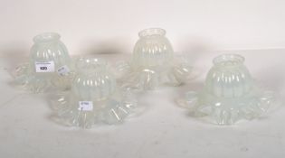 A set of four early 20th century glass light shades, with opaque glaze and fluted rims,